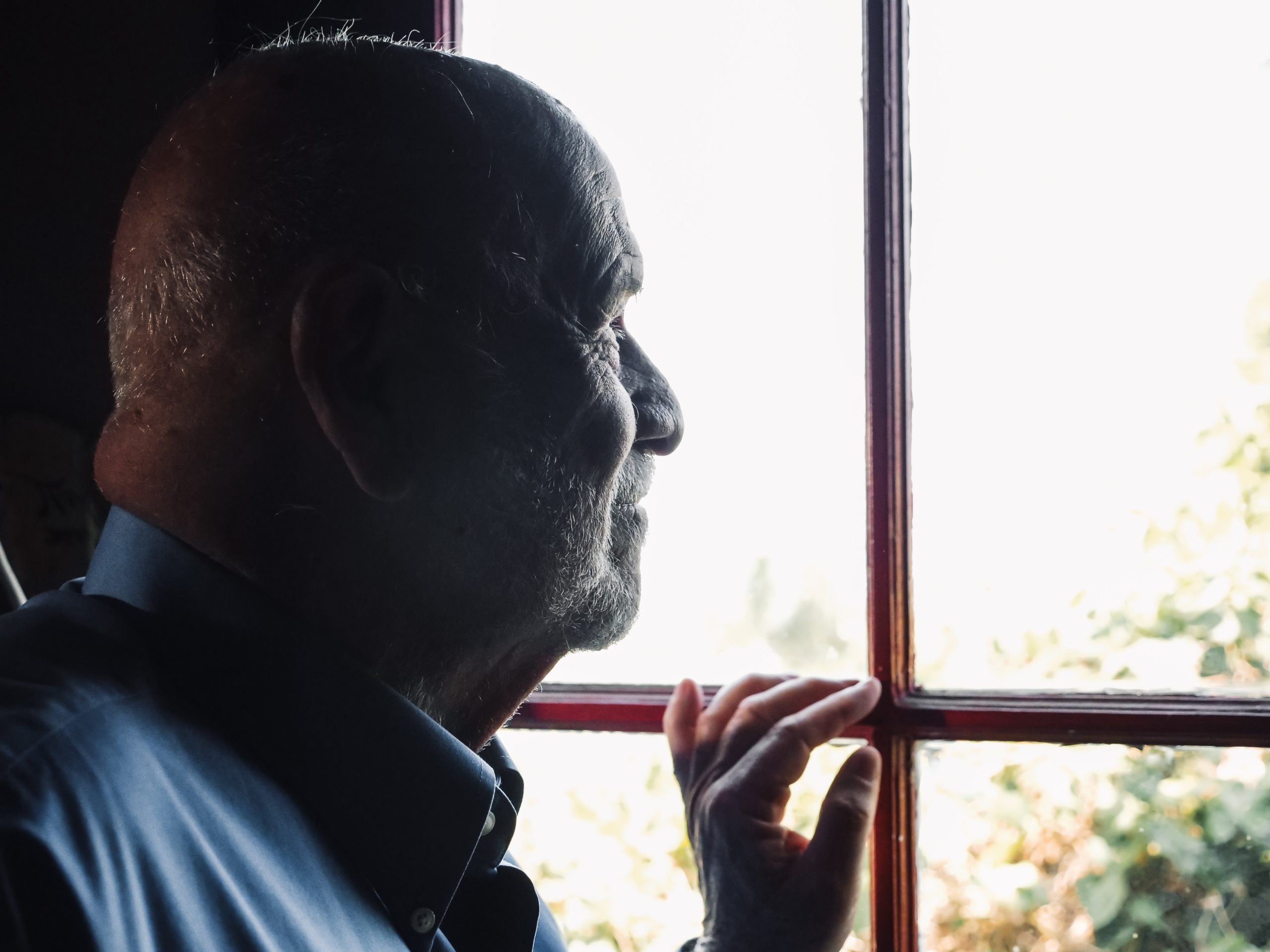 elderly man with dementia at a skilled nursing facility looking out the window