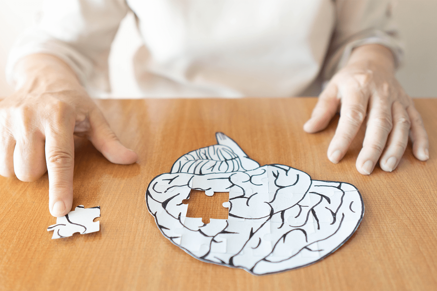 elder with behavioral health problems solving a brain shaped puzzle on table