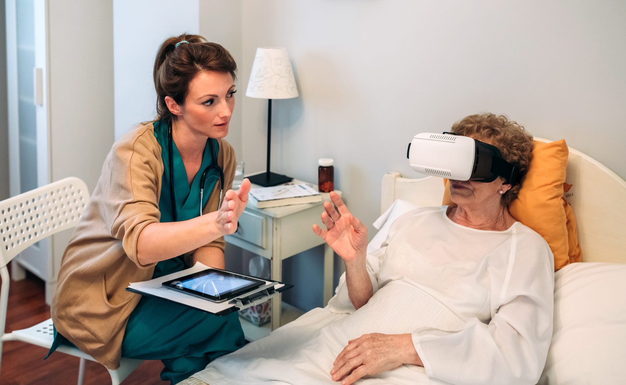 nurse guiding senior women virtual reality pain management therapy session